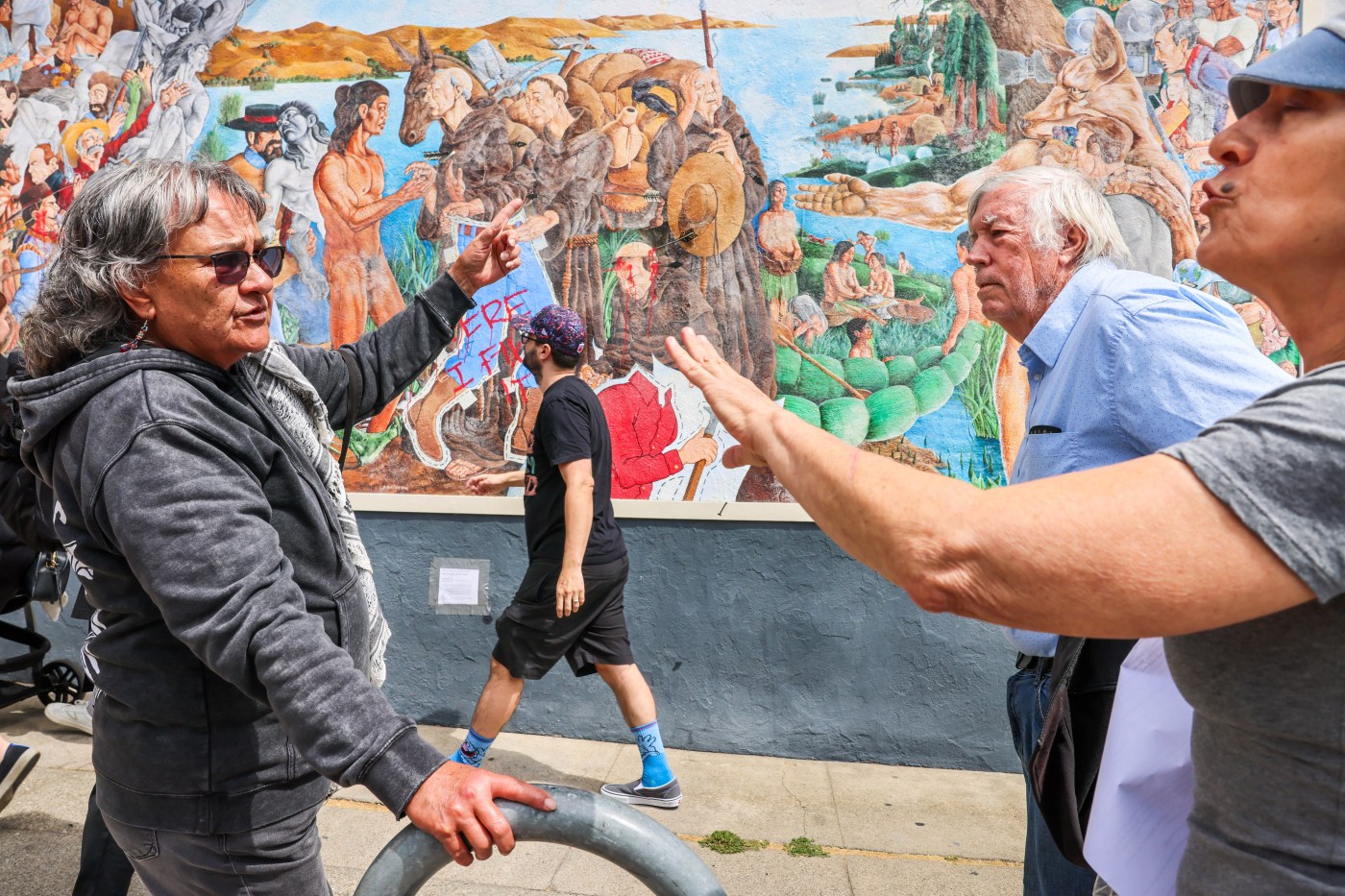 An Oakland mural depicting Native-American genocide was defaced. It led to a debate on the street.